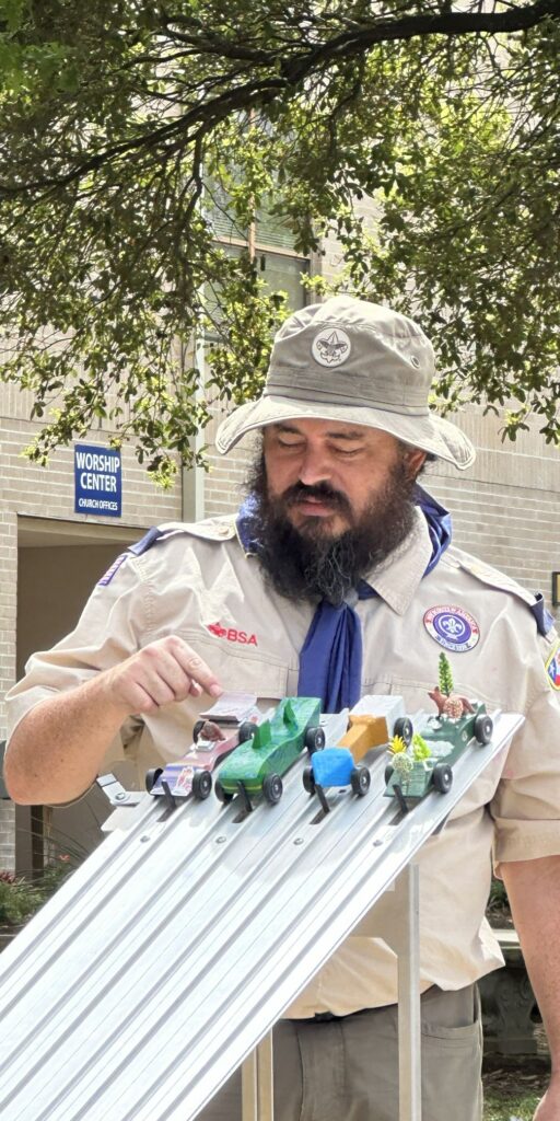Michael Martinez performing the final checks for a pinewood derby heat. Michael is a CISSP who volunteers in the community.